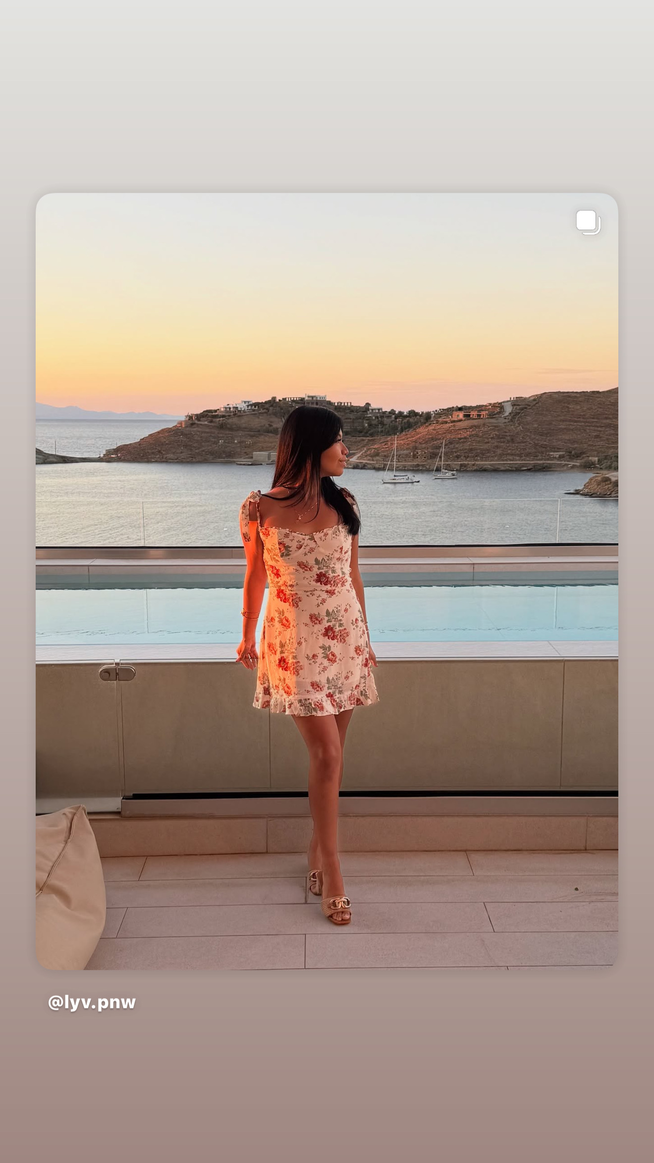 Leslee in a floral dress at golden hour overlooking a Greek bay